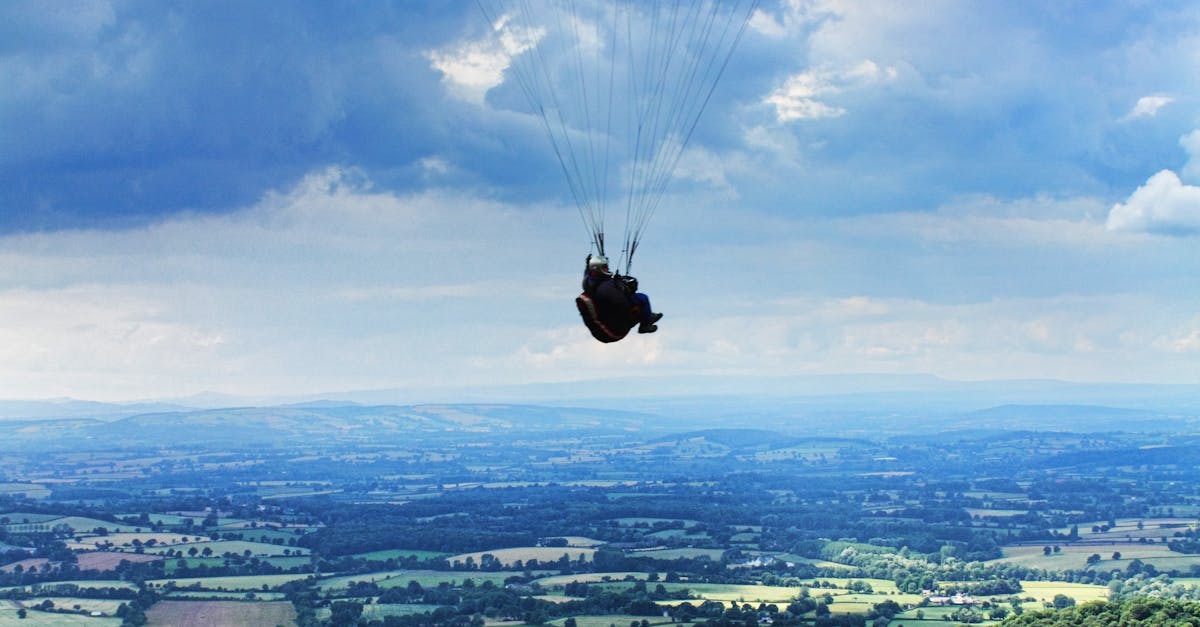 Person Paragliding Under Cloudy Sky